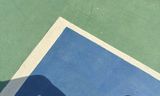 Court shoes on a blue and green outdoor hard court