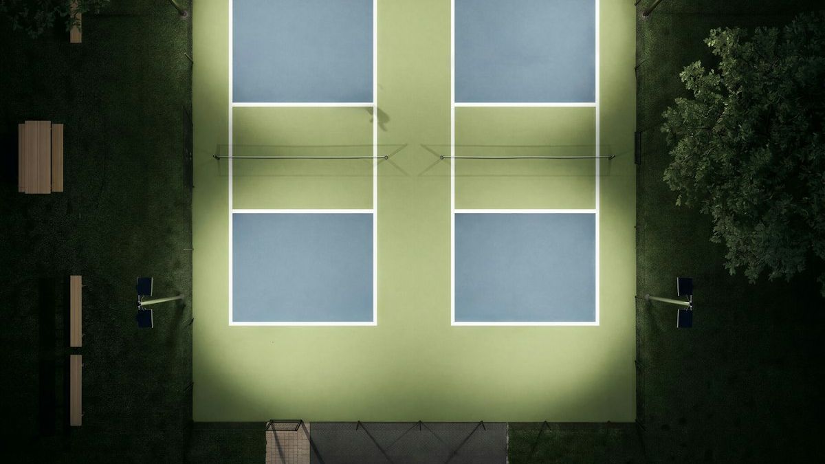 Aerial view of illuminated pickleball courts at a modern sports facility