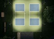 Aerial view of illuminated pickleball courts at a modern sports facility