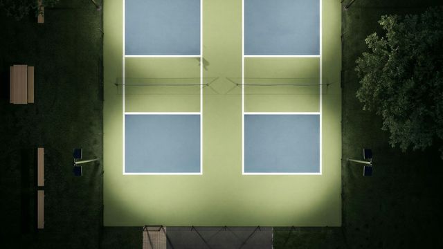 Aerial view of illuminated pickleball courts at a modern sports facility