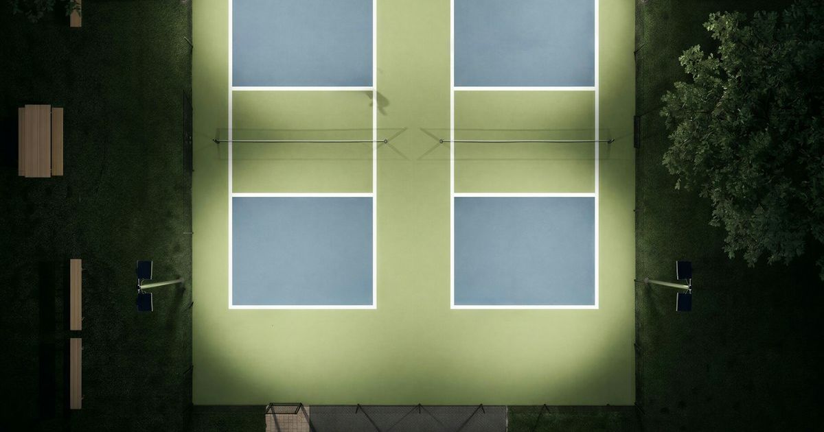 Aerial view of illuminated pickleball courts at a modern sports facility